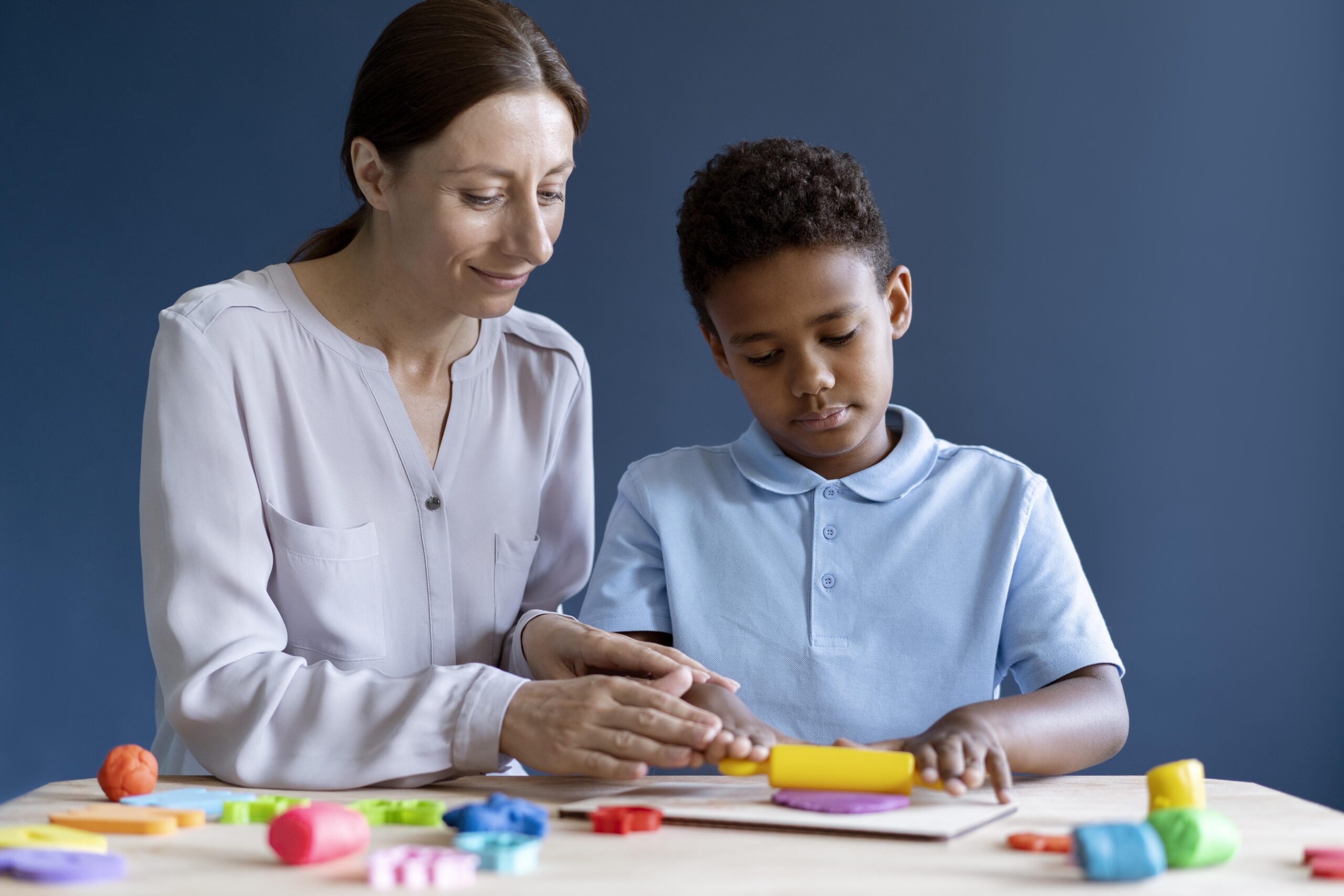 boy doing occupational therapy session with psychologist 2 scaled