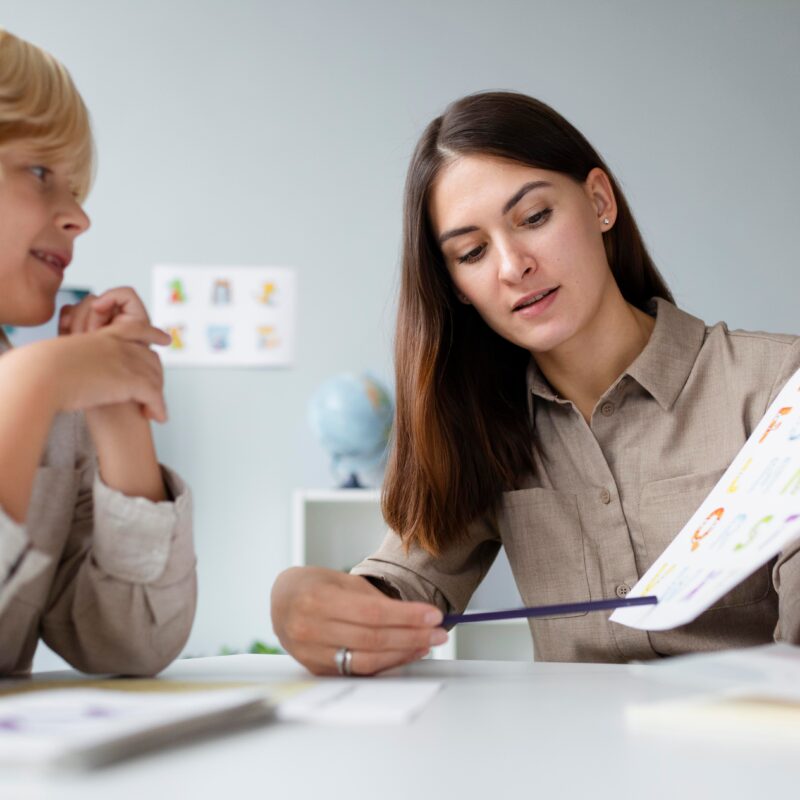 woman doing speech therapy with little blonde boy 1