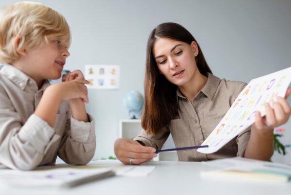 woman doing speech therapy with little blonde boy 1